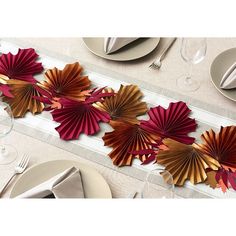 the table runner is decorated with red and gold paper fans