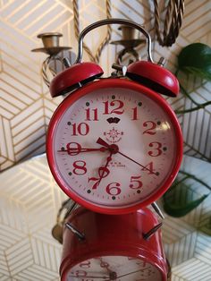 a red alarm clock sitting on top of a table