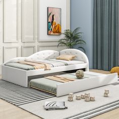 a white bed sitting on top of a wooden floor next to a rug and window