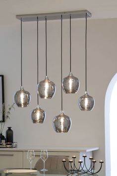 an image of a modern chandelier hanging from the ceiling in a dining room