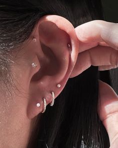 a close up of a person's ear with three piercings