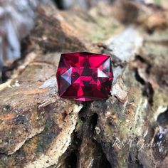 a red diamond sitting on top of a rock