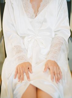 a woman sitting in a chair wearing a white robe