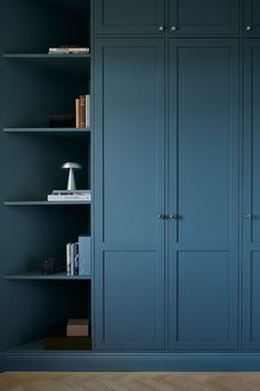 an empty room with blue walls and bookshelves