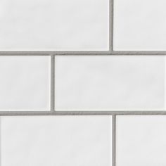 a white tile wall with grey grouting