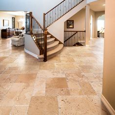 a large foyer with stairs and tile flooring