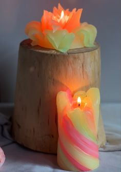 two lit candles sitting next to each other on a table