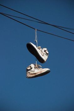 two pairs of shoes hanging from wires with caption that reads, you know you reached the hood when you see these hanging