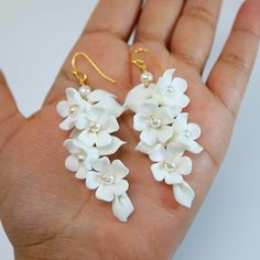 New to our Millennium Bride Collection These Beautiful Romantic WHITE FLOWER PETALS BRIDAL EARRINGS are made of very fine quality of beautifully made Ceramic flowers for your special day! Even we have hard time taking pictures because of their shine 😄 so we want to shine our brides on their special days. The material used in these earrings are free from Lead, Nickel, Cadmium so it will not give you any skin irritation and environment friendly too.. they measure about 7 inches long 3 inches wide White Flower-shaped Cluster Earrings For Anniversary, Handmade White Floral Bridal Earrings For Gift, White Flower-shaped Cluster Earrings For Gifts, White Cluster Flower-shaped Earrings, White Earrings With 3d Flowers For Anniversary, White Flower-shaped Pearl Earrings For Anniversary, White Flower Pearl Earrings For Anniversary, Delicate White Flower Shaped Bridal Earrings, Delicate White Flower-shaped Bridal Earrings