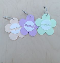 three flower shaped tags with the word cotton written on one side and two flowers in the other