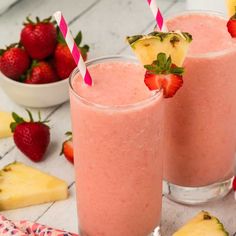 two glasses with strawberries and pineapple on the side, one has a strawberry in it