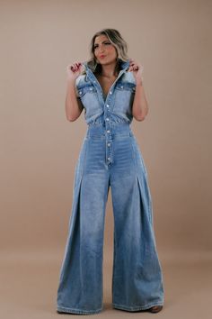 Make a bold style statement with the Doing The Most Denim Button-Up Jumpsuit. This trendy piece combines comfort and fashion in an effortlessly chic design. Dress it down with sneakers for a laid-back look or elevate it with heels for a night out. Denim jumpsuit Functional buttons Collared neckline Snap Buttons Flared bottoms Long Cut-sleeves Denim Imported 90% cotton, 10% polyester Measurements: (Approximate. Measured laying flat *Snap buttons allow for more room in the bust area!) S Waist 30" Button Up Jumpsuit, Flared Bottoms, Short Satin Dress, Denim Jumpsuits, Flare Jumpsuit, Trendy Denim, Long Cut, Everyday Chic, Bold Style