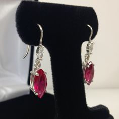 Beautiful Ruby & Sterling Silver Earrings * Marquise Cut Ruby measure 12x6mm each * Marquise Cut White Sapphire Accents * 4.4cts total Gemstone weight * Solid Sterling Silver * Earrings Measure 1 & 1/8 inches Long overall Hallmarked & Gift Ready! Matching Ring and/or Pendant also Available These Stones are Laboratory Grown. They are identical to the Natural Stone in every way including Chemistry, Composition and Hardness with excellent clarity & color refraction. TIMELESS, BEAUTI Pink Teardrop Earrings With Prong Setting, Sterling Silver Marquise Earrings, Sterling Silver Marquise Earrings For Pierced Ears, Classic Pink Drop Earrings, Classic Pink Dangle Jewelry, Classic Pink Dangle Earrings, Formal Drop Cluster Earrings With Ear Wire, Matching Ring, Ruby Earrings