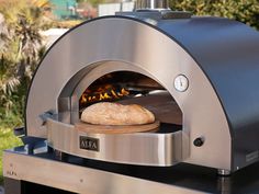 a pizza is being cooked in an outdoor oven