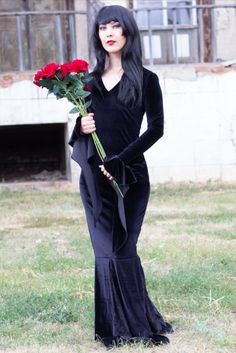 a woman with long black hair holding roses