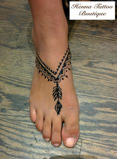 a person with a tattoo on their foot and the words henna tattoo boutique below it