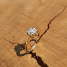 a diamond ring sitting on top of a wooden table