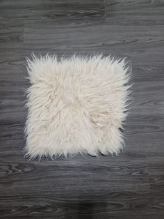 a white sheepskin rug on a wooden floor