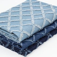 three blue and black blankets stacked on top of each other, one with a diamond pattern