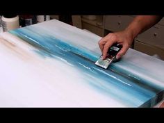 a person is using a brush to paint an abstract painting