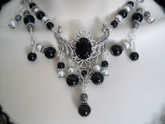 "This beautiful necklace has pewter silver accent beads, black glass beads, white pearl beads, sterling silver plated filigree beads, sterling silver plated bead caps, seed beads, metal chain, sterling silver plated filigree pendant with black crystal setting and rhinestone. It can be worn as a choker or adjusted up to 20\" long. Lobster clasp." Gothic Silver Jewelry With Black Beads, Gothic Metal Jewelry With Black Beads, Gothic Black Beaded Metal Jewelry, Gothic Silver Necklace With Black Beads, Antique Black Jewelry With Intricate Design, Silver Gothic Necklace With Black Beads, Gothic Silver Onyx Necklace, Silver Onyx Gothic Necklace, Elegant Antique Silver Necklace With Silver Beads