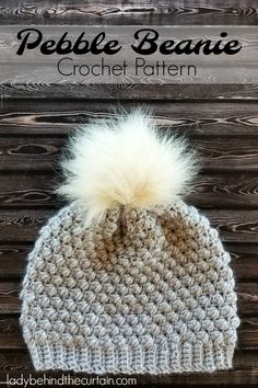 a crocheted beanie with a white pom - pom on top