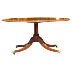 a wooden table with wheels on the legs and a circular center piece inlaid to it