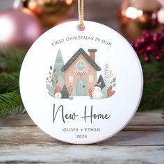 a christmas ornament with a house on the front and words that reads, first christmas in our new home