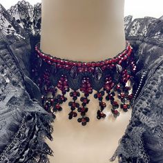 Dear customers, for a price offer of expedited shipping outside of Germany, please contact me directly via Etsy messages. Gothic Victorian Royal collar made with black lace flowers and hand sewn deep red round leafs & beads, the perfect decoration for a gothic queens neck, amazing addition for a unique gothic wedding, or even a vampire Halloween costume! Goth fashion is distinguished by darkness, mystery, elegant wardrobe pieces and, smoky makeup even though it may surprise some that not all Got Vintage Red Choker For Party, Handmade Vampire Style Jewelry For Party, Black Vampire Style Choker As Gift, Gothic Choker For Party, Red Gothic Choker For Festivals, Red Choker For Halloween Party, Red Gothic Jewelry For Party, Handmade Vampire Style Party Necklace, Red Beaded Choker For Party