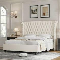 a white bed with tufted headboard and foot board