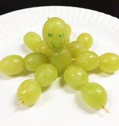 a white paper plate with grapes on it