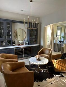 a living room filled with lots of furniture and a chandelier hanging from the ceiling