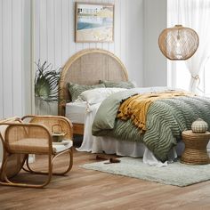 a bedroom with white walls and wood flooring has a rattan headboard on the bed