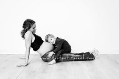 a pregnant woman sitting on the floor with her child