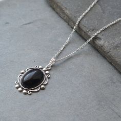 "Vintage Style Black Onyx Sterling Silver Necklace A pretty vintage Victorian style Black Onyx Pendant The black onyx stone measures 14 mm x 10 mm and is set in a pretty decorated Sterling silver plated brass vintage    style setting that measures 20 mm x 17 mm. It suspends from a sterling silver trace chain that has a spring ring fastening and is available in a choice of 16\" or 18\" length. Would make a lovely gift for that someone special. Your necklace will arrive gift boxed." Formal Black Engraved Necklace, Gothic Onyx Necklace Gift, Gothic Onyx Necklace As A Gift, Victorian Style Silver Onyx Jewelry, Victorian Silver Onyx Jewelry, Elegant Black Cabochon Necklace, Black Cabochon Victorian Jewelry, Victorian Black Cabochon Jewelry, Ornate Black Metal Necklace