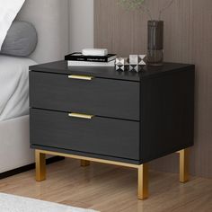 a black and gold bedside table with two drawers on each side next to a white bed