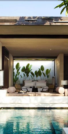 an outdoor living area with couches and tables next to a swimming pool