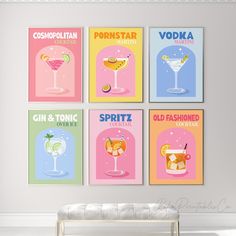 four colorful cocktail posters hanging on the wall above a bench in a room with white walls