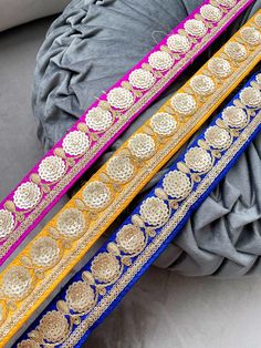 two different colored belts with gold and blue trims