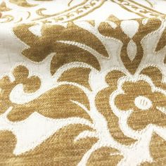 the fabric is gold and white with an intricate design on it's back side