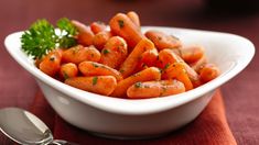 a white bowl filled with carrots on top of a table