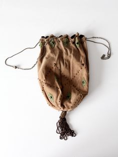 "This is an early 20th century antique evening bag. The drawstring reticule features a plush velvet like tan fabric body with a subtle herringbone weave tan accented with a lovely beaded floral design and brown beaded tassel. A stunning silver tone metal chain with bead accents closes and carries the bag. CONDITION In good condition with wear consistent with age and use. One small brown center floral bead is missing. MEASUREMENTS Length: 8.5\" ... 21.6 cm Width: 6.25\" .. 15.9 cm Drop: 9.5\" .. Vintage Beaded Beige Bags, Traditional Handmade Bags For Vintage Events, Vintage Brown Bag As Fashion Accessory, Vintage Brown Bags As Fashion Accessory, Elegant Beaded Shoulder Bag For Travel, Evening Embroidered Brown Shoulder Bag, Bohemian Evening Pouch Bag, Beige Pouch Potli Bag For Evening, Vintage Brown Pouch Evening Bag