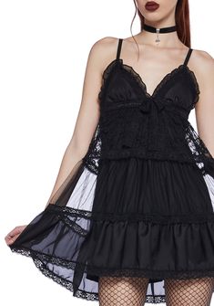 cuz you love alchemy. This mini slip dress is fully lined, has a sheer mesh overlay, floral lace detailing, a tiered design, adjustable shoulder straps, a plunging neckline, a ruffled bust, and a decorative bow on the front and back. Goth Sundress, Babydoll Dress Nightwear, Slip Mini Dress, Black Dolls, Corset Mini Dress, Mini Slip, Mesh Overlay, Black Doll, Mini Slip Dress