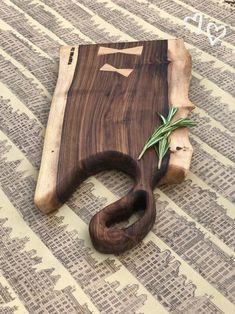 a wooden cutting board with an olive branch on it