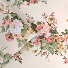 the wall paper has flowers on it and is white with pink, yellow and green leaves