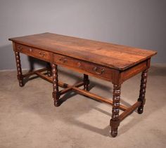 an old wooden table with two drawers on the top and one drawer at the bottom