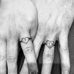 two people with heart tattoos on their fingers