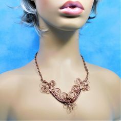 Non tarnish antique colored copper wire is hand woven, sculpted, and wrapped with copper beads, to form a light weight, one of a kind bib style necklace that is elegant enough for formal wear, and yet understated enough for casual every day wardrobe choices. The bib is suspended from individually wire wrapped beaded links, creating an elegantly detailed piece of artisan crafted jewelry that stands the test of time. The total length, including beaded link chain, measures 20 inches. Your one of a Copper Wire Wrapped Necklace For Festivals, Festival Wire Wrapped Copper Necklaces, Handmade Copper Wire Gold Necklace, Festival Copper Wire Wrapped Necklaces, Festival Wire Wrapped Copper Necklace, Handmade Gold Copper Wire Necklace, Festival Copper Wire Wrapped Necklace, Handmade Gold Necklace With Copper Wire, Bohemian Copper Electroformed Necklace