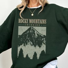 This Colorado sweatshirt makes a totally unique Colorado gift or souvenir for anyone visiting, coming from, or living in Colorado who loves hiking the Rocky Mountains. Grab this sweater today while it's on sale! Delivery Times: ◦ Production: 1 business day (avg.)  ◦ Shipping: 3 business days (avg.) Overview: Ultra-Comfy Feel: The air-jet spun yarn creates a luxuriously soft feel against your skin, perfect for lounging or layering. Classic Fit: Perfect for that oversized look or just a classic fi Fall Hiking T-shirt With Graphic Print, Casual Sweatshirt With Letter Print For Outdoor, Casual Sweatshirt With Letter Print For Outdoor Activities, Casual Crew Neck Sweatshirt For Adventure, Casual Letter Print Sweatshirt For Outdoor Activities, Fall Hiking Sweatshirt With Letter Print, Fall Hiking Sweatshirt Crew Neck, Fall Hiking Crew Neck Sweatshirt, Fall Crew Neck Sweatshirt For Hiking