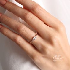 a woman's hand with a diamond ring on it